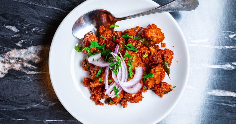 Chicken 65 topped with diced onion and herbs