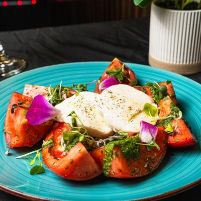 Caprese salad with fresh mozzarella and basil pesto.