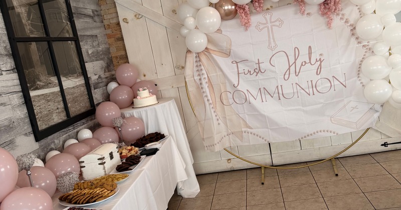 Table with snacks and balloons and a First Holy Communion banner