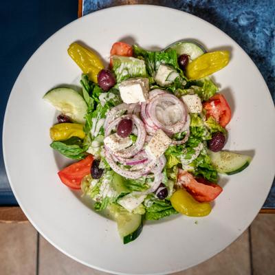 House salad with greens, red onions, cucumbers, tomato, pepperoncini, olives and feta.