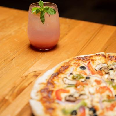 Veggie pizza and a hazy red cocktail.