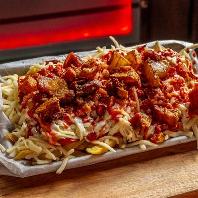 French fries loaded with sausage, chicken, cheese, pork rinds, ketchup, and sauces.