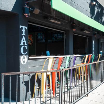 Taco Loco outdoor seating with colorful stools and open windows.