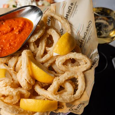 Crispy calamari with lemon wedges and spicy marinara sauce.