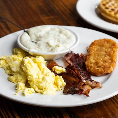 Scrambled eggs, bacon, hash browns, and grits.