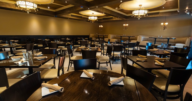 Interior of a restaurant with dark wooden furniture and elegant chandeliers