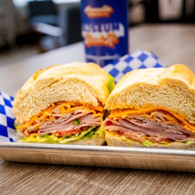 Ham and turkey sandwich with cheese and lettuce.