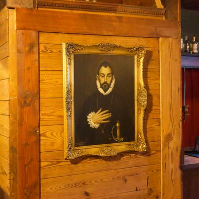 Framed portrait painting on a wooden wall.