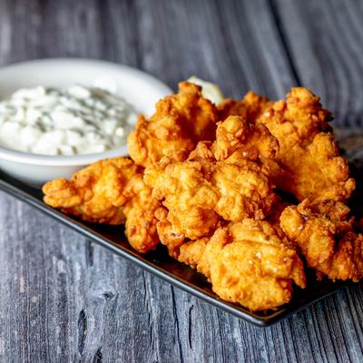 Fresh fried haddock served with a side of tartar sauce.