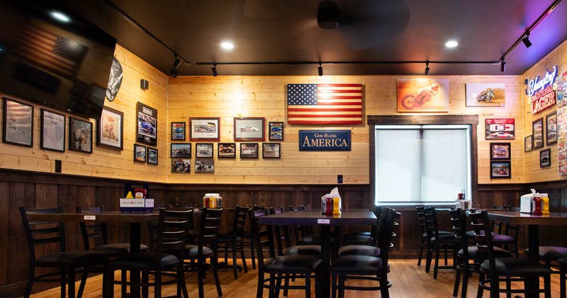 A cozy, Americana-themed restaurant with wooden walls displaying an American flag
