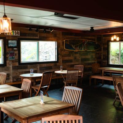 Restaurant interior featuring rustic wood-paneled walls, wooden tables, and chairs.