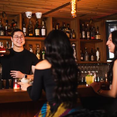 A bartender and guests interacting.