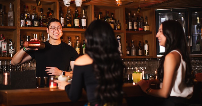 Interior, a bartender interacting with guests at a bar counter