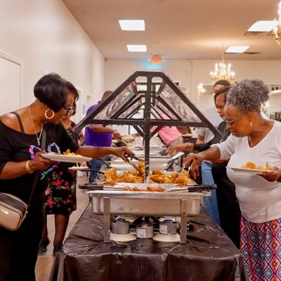 Group of people gathered around a food display booth.