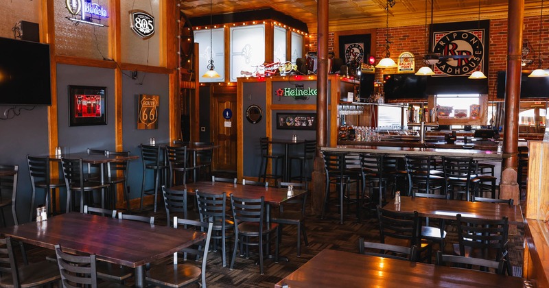 Interior, seating area, high and regular tables ready for guests, bar with stools