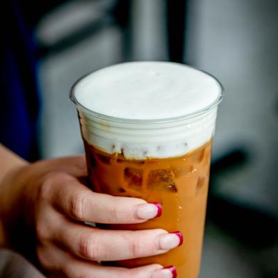 White mocha Americano cup in a person's hand.