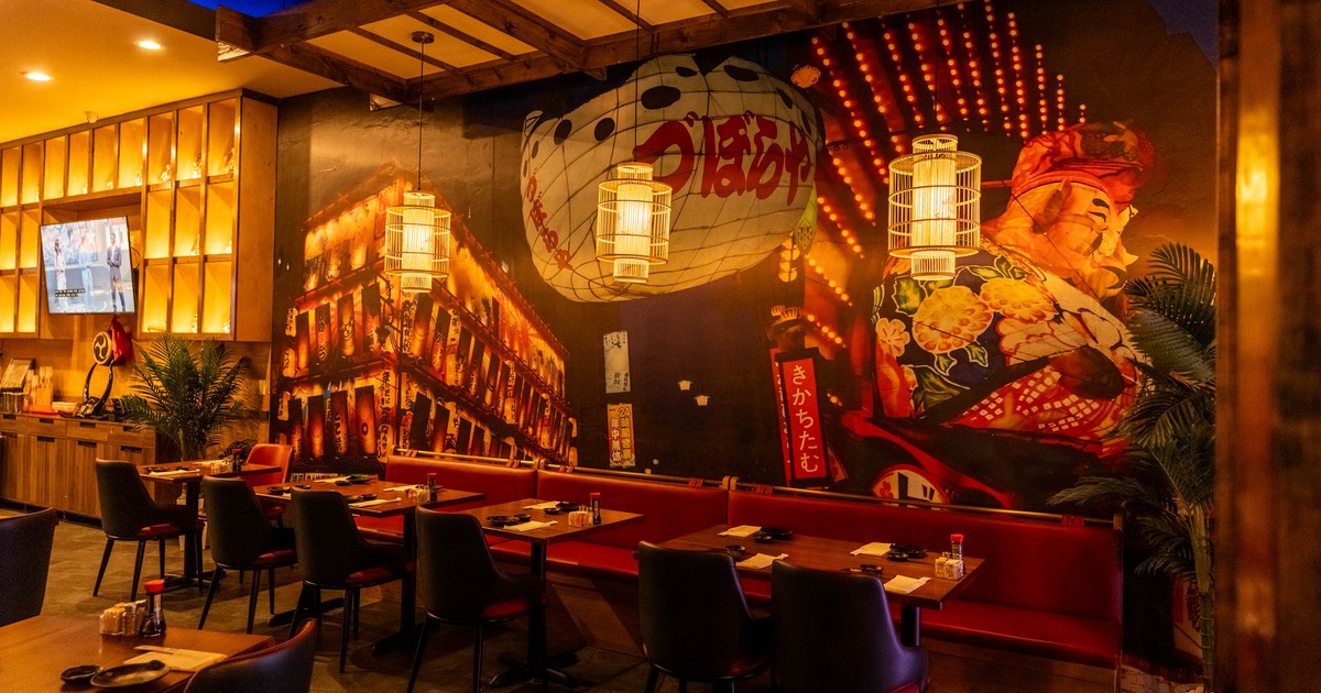 Interior featuring a dramatic mural of a traditional figure and Japanese paper lanterns