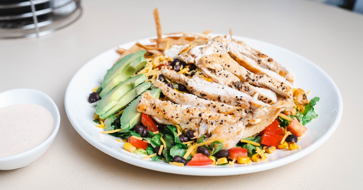Southwest Salad topped with grilled chicken and avocado slices