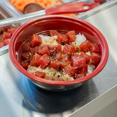 Tuna poke bowl with diced fish, rice, and sesame seeds.