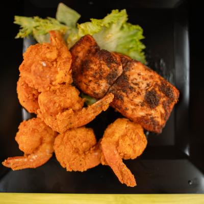 Fried seafood platter with battered shrimp and blackened salmon.
