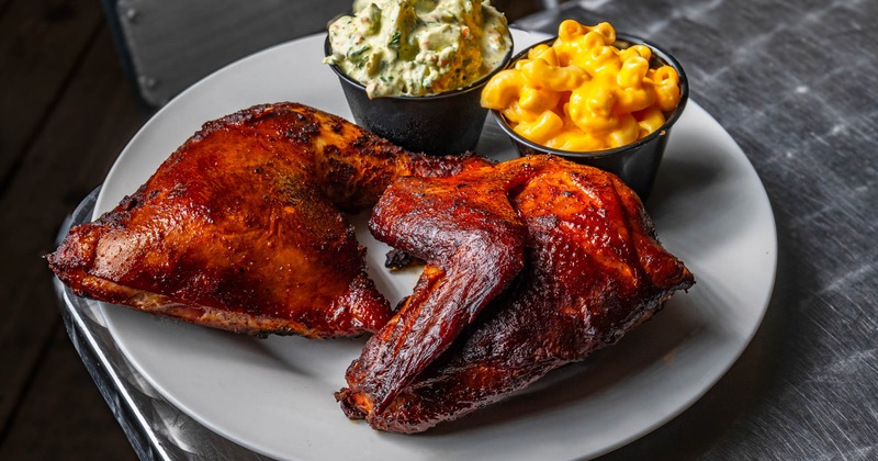 Smoked chicken served with mac and cheese and a potato salad