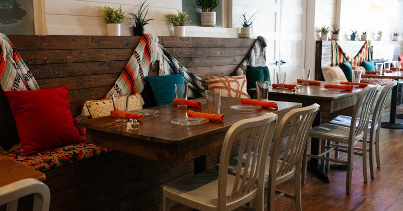 Interior, wooden banquette bench and tables with chairs, ready for guests