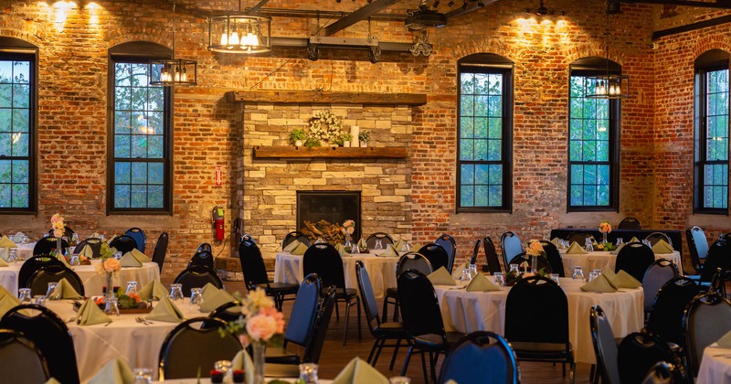 Interior, banquette area, stone and brick walls, round tables for eight, high ceiling