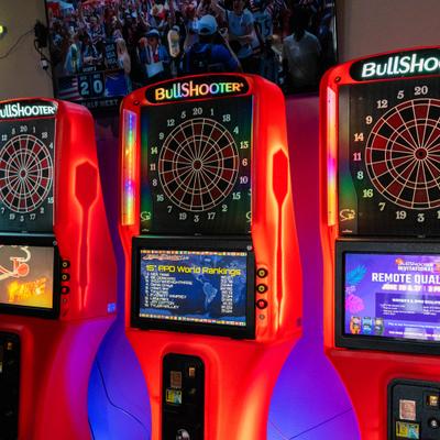 Red-lit electronic dartboard machines.