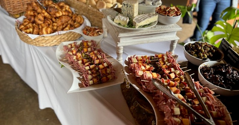 A grazing table with pastries, cheese, olives, meat and cheese skewers