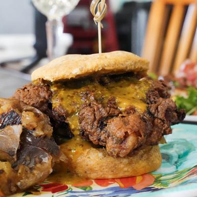 A close-up of a crispy chicken sandwich topped with melted cheese.
