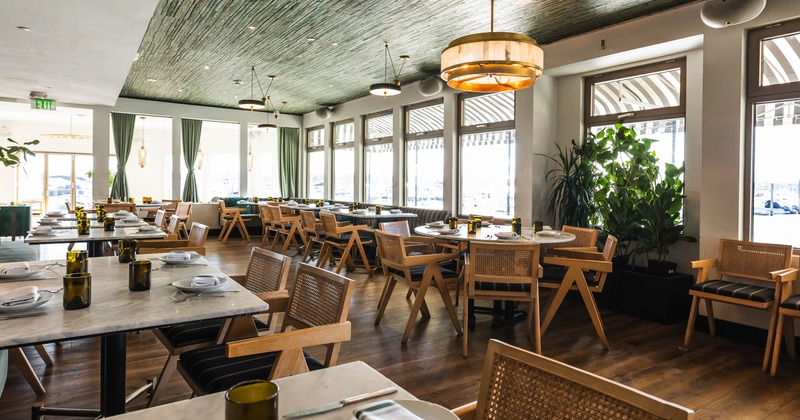 Bright restaurant dining room with wooden chairs and large windows