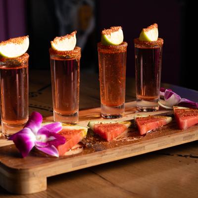 Watermelon cocktail flight, served on a wooden board.