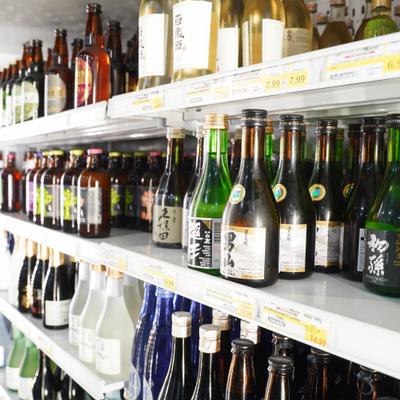 Shelves filled with various bottles of Japanese sake and beer, neatly organized.