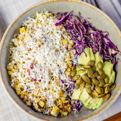 Roasted corn bowl with avocado, cabbage, and pepitas.