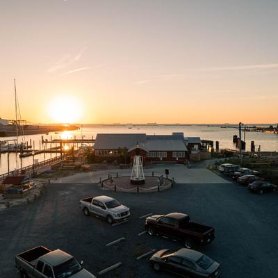 An aerial shot capturing the sunset's beauty above the restaurant and a parking lot.