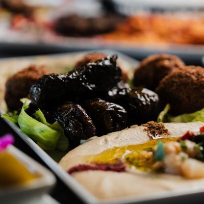 Appetizer plate with falafel, hummus, and stuffed grape leaves.