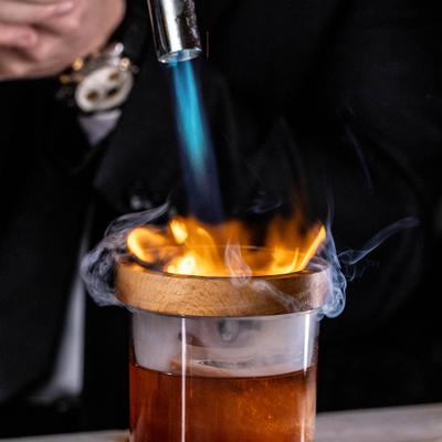 Bartender smoking an Old Fashioned cocktail.