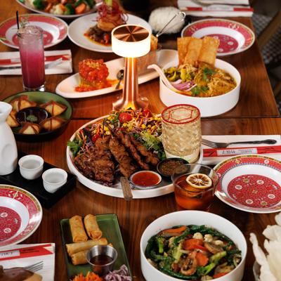A variety of food dishes and drinks served on a wooden table.