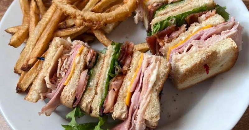 Club sandwich served with crispy fries and onion rings