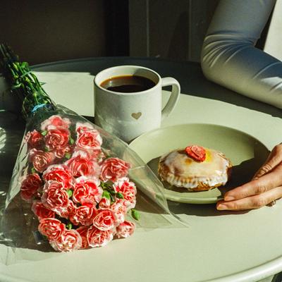 A served dessert with coffee and a flower decoration.