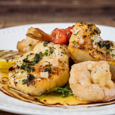 Chilean Seabass and shrimp with cherry tomatoes, garlic, fresh herbs, and lemon.