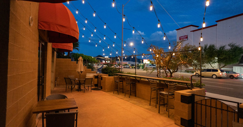 Patio with string lights, tables and chairs ready for guests