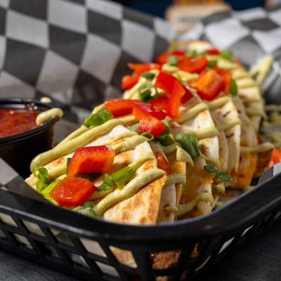 Blackened steak quesadilla served with red salsa, close up.