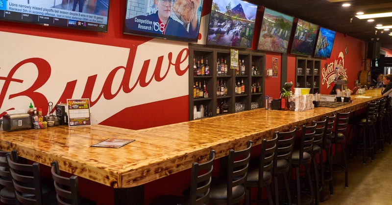 Long counter and bar stools and TVs on the wall