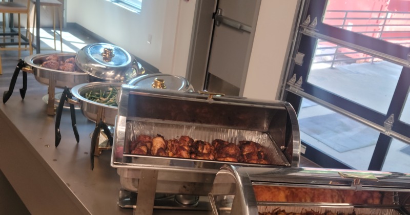 A buffet line with several chafing dishes containing food