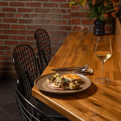 Seafood dish served on a counter with a glass of white wine.