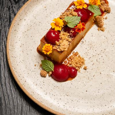 Dessert topped with various garnishes, served on the plate, close-up.