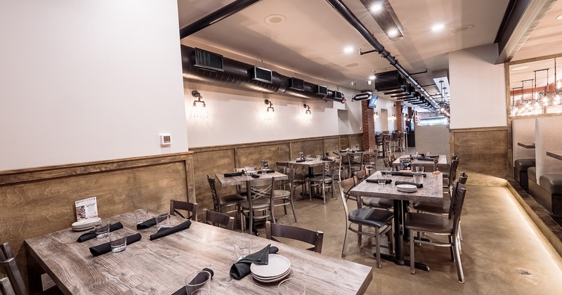 Interior of spacious and cozy dining area with tables set for guests
