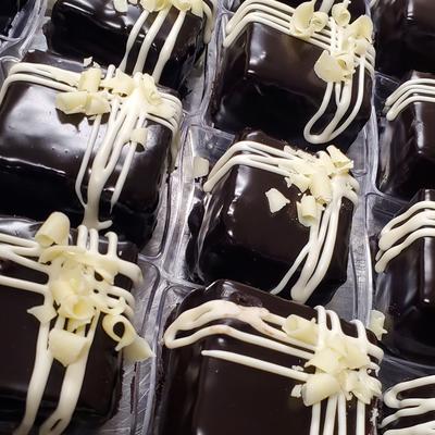Close-up of chocolate cakes drizzled with white icing.