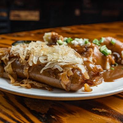 Braised sausages and caramelized onion gravy on a bed of mashed potatoes.